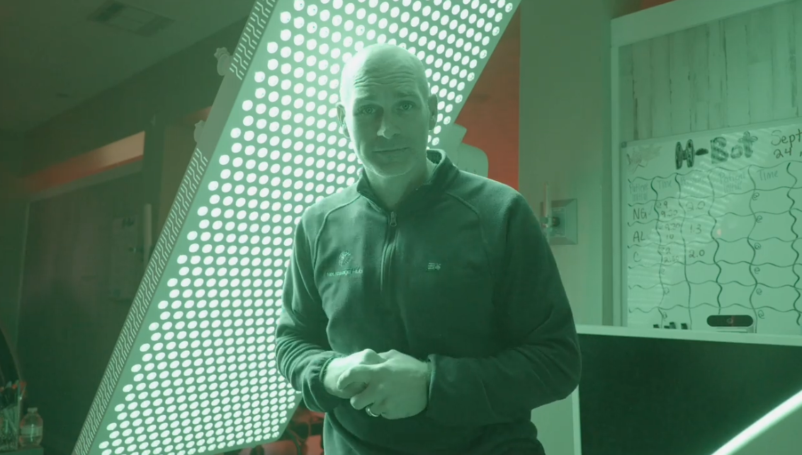 Dr. Kyle Daigle standing in a clinic room lit in green.